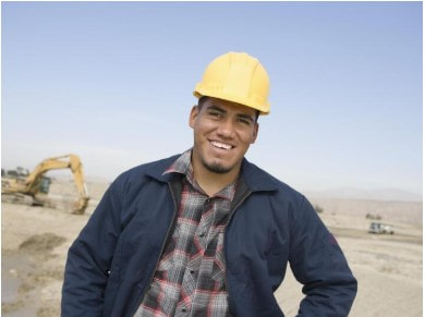 Smiling man in hard hat at septic job site